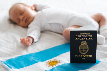 Argentinean passport and flag on background of cute caucasian newborn baby sleeping lying on bed. Concept of getting citizenship, childbirth, delivery in Argentine.