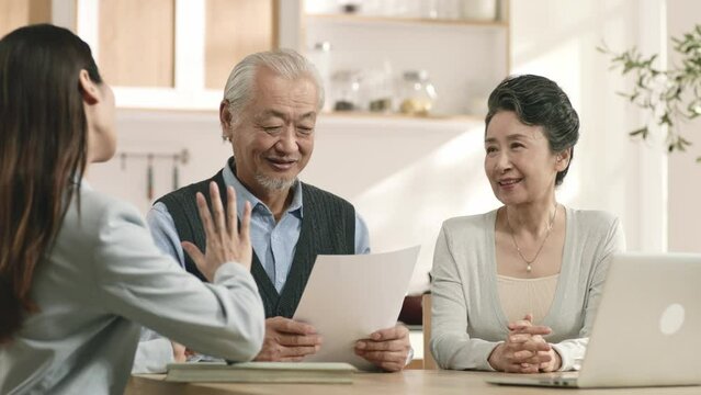 asian sales woman selling product to old couple who happily signed the contract