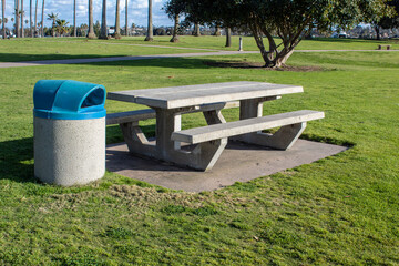 Concrete picnic table with trash bin on the side.