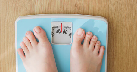 woman measure weight on scale