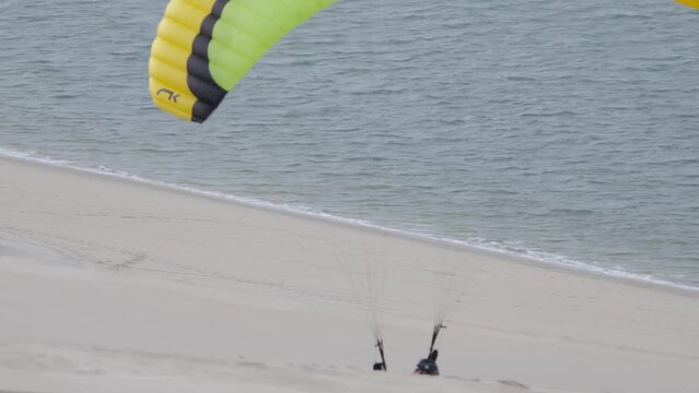 Male paraglider paragliding on Dune du Pilat in France, taking off view, ocean background