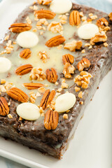Freshly baked chocolate loaf cake with a variety of crushed nuts.