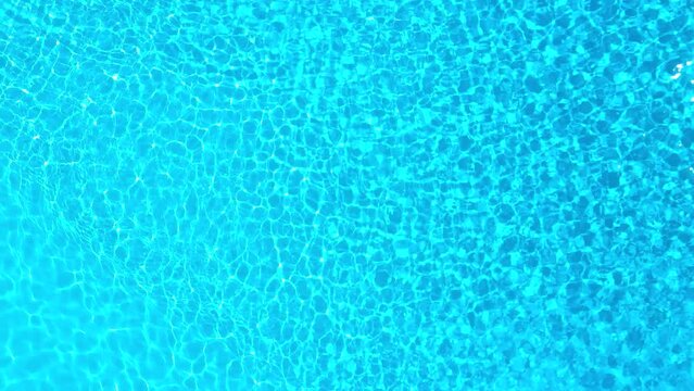 Blue water in the swimming pool with light reflections.