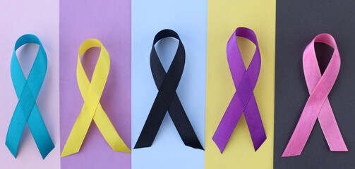 World cancer day. Colorful awareness ribbons on different color background for supporting people...