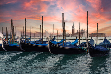 Naklejka premium Gondolas moored in grand canal, with San Giorgio di Maggiore church at sunset in Venice, Italy - Travel concept