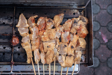 selective focus on tofu filled with meatballs, which are grilled over charcoal