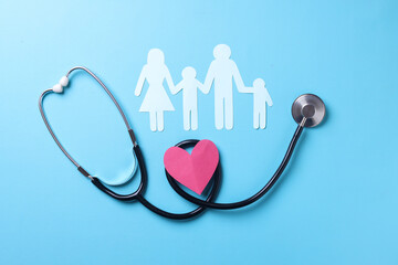 Family insurance and medical care concept. Flat lay with heart shape, stethoscope and family figure. 