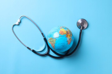Globe with stethoscope isolated on blue background. Save the wold, Global healthcare and Green...