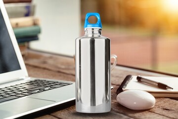 Works at office with thermos bottle on desk