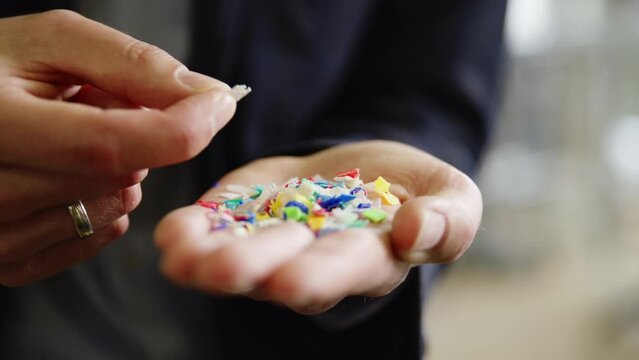 Closeup of colorful plastic granules in a palm