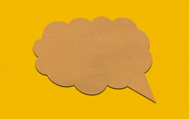 Brown paper speech bubble on yellow paper background.