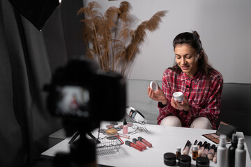 Beautiful hispanic woman blogger is showing how use cosmetics and to make up. To recording vlog...