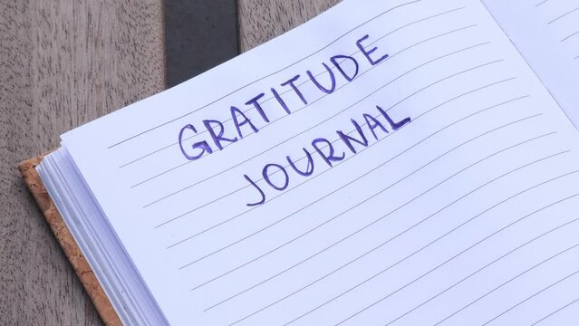 Writing Gratitude Journal on wooden bench. Today I am grateful for. Self discovery journal, self reflection creative writing, self growth personal development concept. Self care wellbeing spiritual