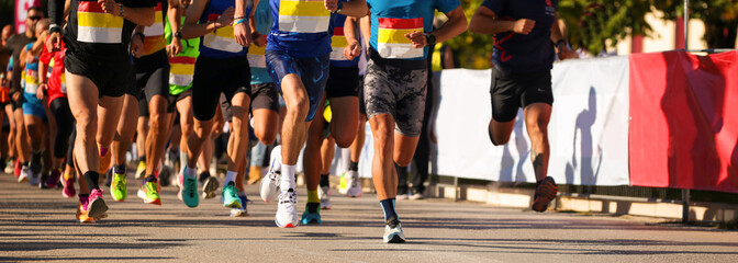 runners in start line shioes feet crowd in asphalt city running marathon