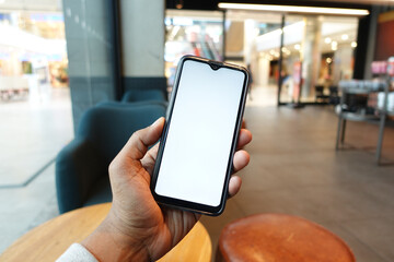 young man hand using smart phone with green screen at cafe 