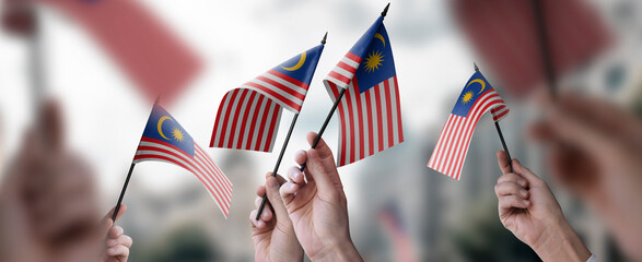 A group of people holding small flags of the Malaysia in their hands