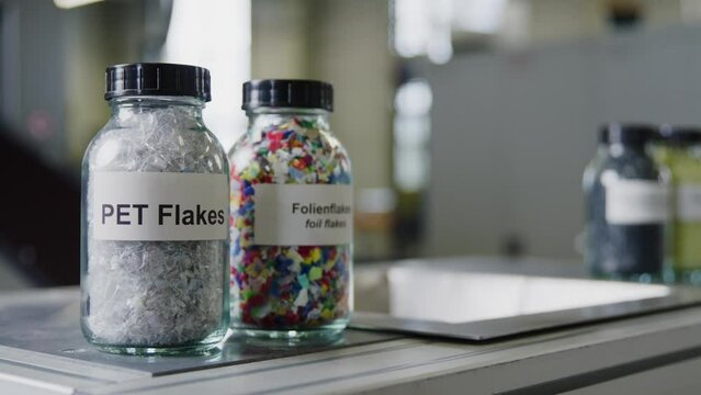 Shot of bottles with plastic flakes; white and color