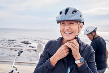 Happy senior woman, bicycle and helmet on holiday ride at beach for fitness workout with man. Smile...