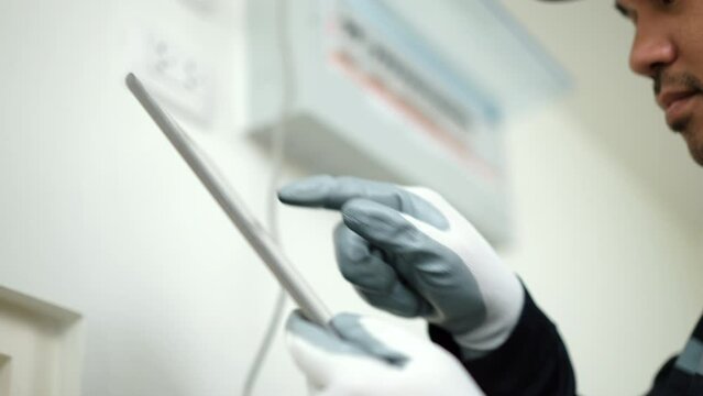 Close up technicians in uniform installing network cable and using tablet  for maintenance. Electrician man checking home internet network. Home service concept.