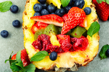 Exotic fruit salad in half a pineapple.