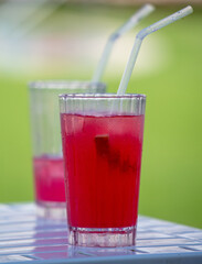 Red cocktail in a glass in nature.