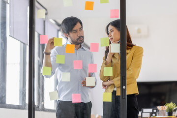 Team of Business female employee with many conflicting priorities arranging sticky notes commenting...