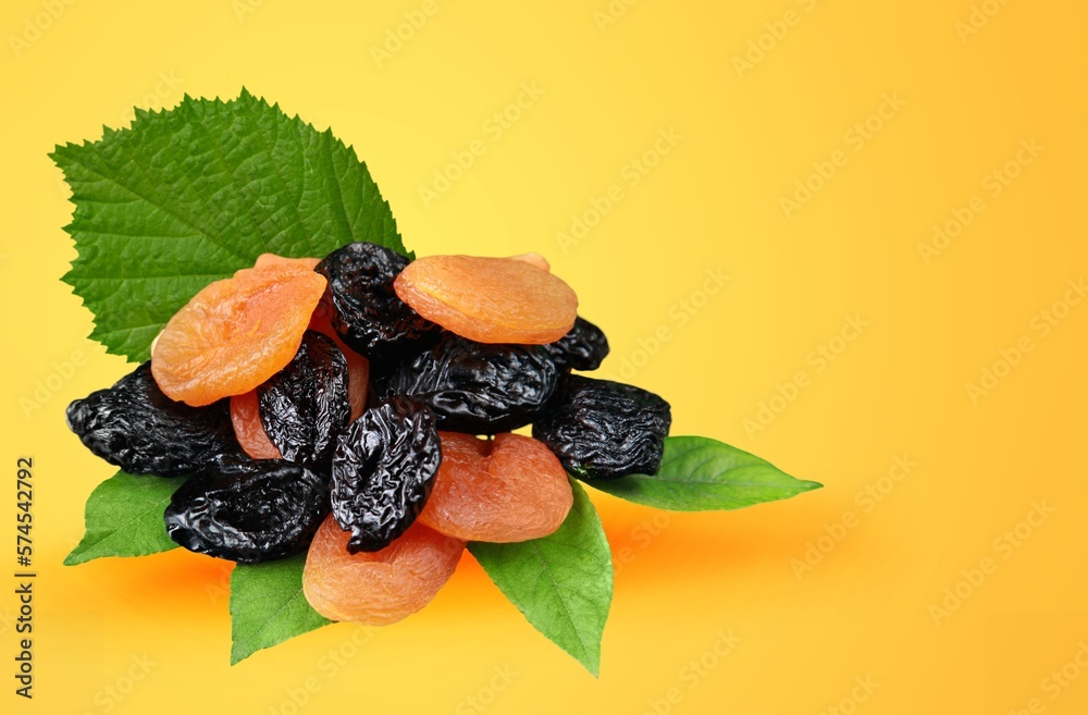 Wall mural Dried fruits with nuts mixed with fresh green leaves.