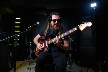 Obraz na płótnie Canvas Guitarist man plays an electric guitar Close-up at studio
