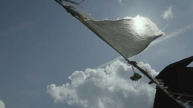 White flag raised on rope near building by Russian soldiers in Ukraine against sunshine