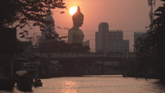Evening sunset behind the Giant Buddha Statue at Wat Paknam Phasi Charoen in Bangkok, Thailand.