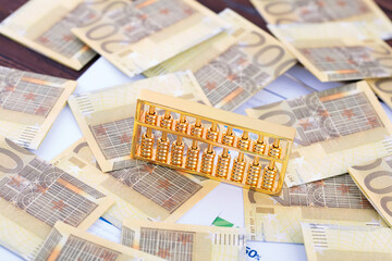 The gold abacus is on the background of a euro note