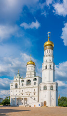 Ivan the Great Bell Tower, with Assumption Belfry on the right in Moscow Kremlin. Blue sky background with sunbeams