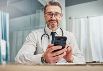 Obraz na płótnie Canvas Healthcare, smile and doctor with smartphone at desk for wellness research, medical app and online consulting. Hospital, clinic and happy man with phone for internet, communication and telehealth