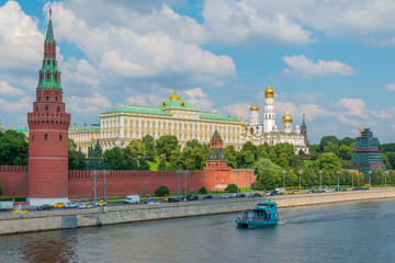 Obraz premium View of Kremlin with Vodovzvodnaya tower, Grand Kremlin Palace from repaired Bolshoy Kamenny Bridge in Moscow city on sunny summer day. Cruise ship sails on the Moscow river