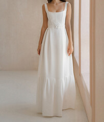 Beautiful bride in the white long wedding dress. Classic sleeveless wedding dress with deep...