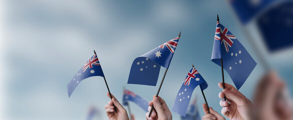A group of people holding small flags of the Australia in their hands