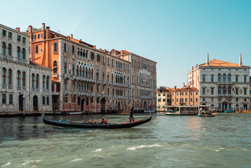 The Grand Canal lined either side with Palazzo Giustinian, Ca' Foscari, Palazzo Balbi, public buildings, gondolas, and local water transport in Venice, Italy.