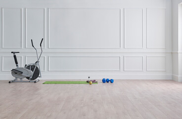 Sport in the room, classic white wall, bike, green gym mat, dumbbell and water style.