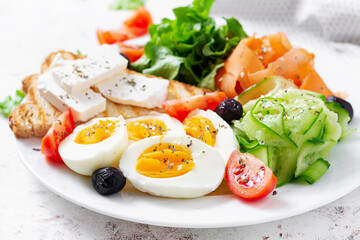 Healthy breakfast. Salad with feta cheese, eggs, cucumber and carrot. Healthy balanced food.