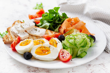 Healthy breakfast. Salad with feta cheese, eggs, cucumber and carrot. Healthy balanced food.