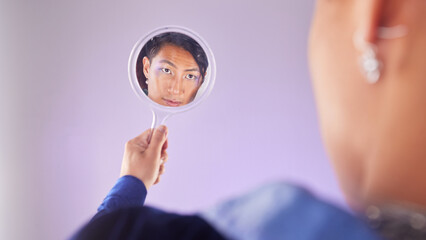 Makeup, reflection and gay man with mirror in hand with pride on purple background. Cosmetics, aesthetic and art, lgbt fashion model face with beauty in studio, non binary and gender neutral skincare