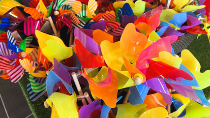 A bunch of colorful pinwheel toys in a basket at a store