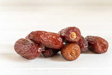 Date fruits on white wooden background.