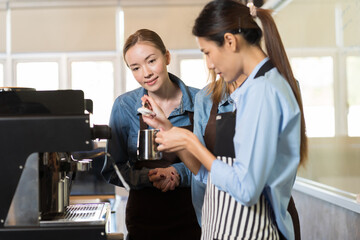 Group of young barista woman preparing coffee for customer in the cafe shop. Group of female waitress making coffee on steam espresso coffee machine at cafe shop