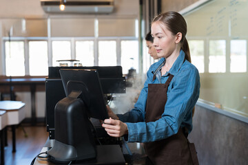 Smiling woman barista take order from customer in coffee shop. Female barista using computer desktop take order. Coffee owner concept