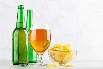 Beer glass, beer bottles and potato chips