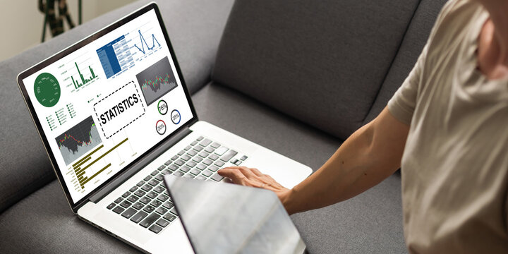 Laptop Computer Showing Statistical Infographics Stands on a Desk in the Living Room. In the Background Cozy Living Room.