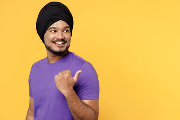 Smiling devotee Sikh Indian man ties his traditional turban dastar wear purple t-shirt point thumb...