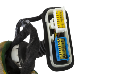 A modern car connector or trailer for closing an electrical circuit that a mechanic holds in gloves during repairs.