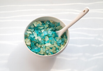 Top view of natural sea salt in bowl on white background.